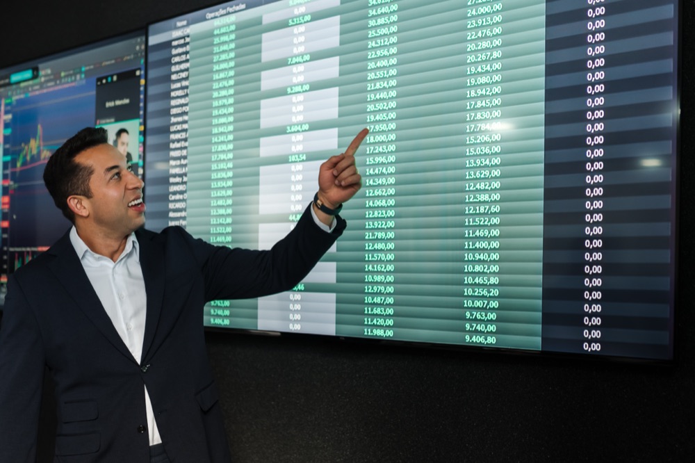 Ariel Fernandes apontando para painel de resultados dos sócios da TSR